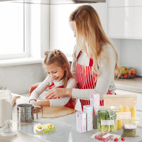 Mother and daughter using No Sweat Mini Bag Sealer and Cutter; kitchen with snacks and sealed food. Portable green device visible.