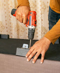 Installation of versatile 100 piece round PVC floor protectors with quiet glide on furniture using a drill.