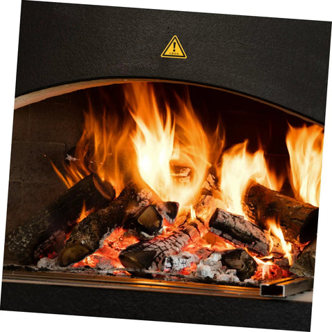 Fireplace with logs burning brightly under a caution sticker, showcasing a safety warning in use context.
