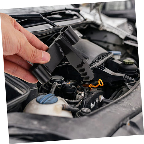 Close-up of black FELTECHELECTR flywheel holding tool held by hand over a car engine bay.
