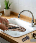Get That Crisp Laundry Glow With This Washing Machine Cleaning Brush Kit Built For Top Load And Front Load Washers To Slap Off Grime And Reach Those Tight Crevices Easily Without Breaking A Sweat On Your Next Chore - cleaning brush in use with washer parts in sink.
