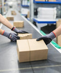 MicroFoam Nitrile Coated Safety Work Gloves With 3D Seamless Knit Nylon Grippy in use by workers handling boxes in a warehouse.
