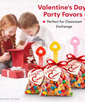 Valentine's Day gift bags with candy shovels for classroom exchange, featuring colorful candy and red ribbon.