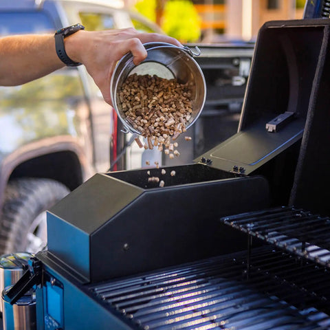 Person filling 7 lb hopper with all natural hardwood pellets on Table Top Wood Pellet Grill With Flame Broiler For Direct Searing Up To 1000°F