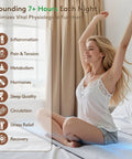 Woman sitting on Graphene Grounding Mat For King Bed promoting relaxation, stress relief, conductive sleep pad for deep sleep and energy.