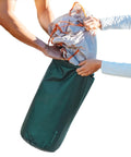 Hands placing gear into 20L Ripstop Stuff Bag With Water Resistant DWR Coating Lightweight Outdoor Drawstring Sack for camping.