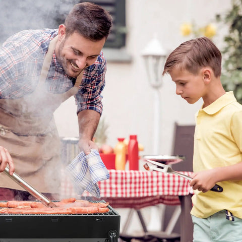 Father and child grilling sausages outdoors on Grab And Go Portable Folding Charcoal Grill And Smoker For Travel And Outdoors