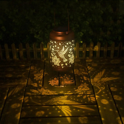 Hummingbird Solar Lanterns For Outdoor Garden Decor illuminating a wooden patio with gold copper finish, retro hummingbird design.