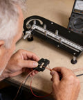 User shaping wires with Ergonomic Precision Wire Bender Tool For Tight Cable Forming And Quick Custom Bends on a workbench.
