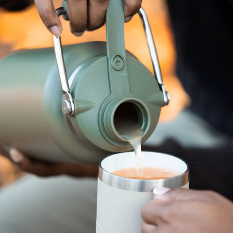 Person pouring from a Half Gallon Stainless Steel Water Jug With Ceramic Lined Interior Double Wall Insulated Cooler Bottle.