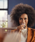 Woman enjoying espresso from Ready To Brew Renewed Fully Automatic Espresso Machine With Button Touch Controls.