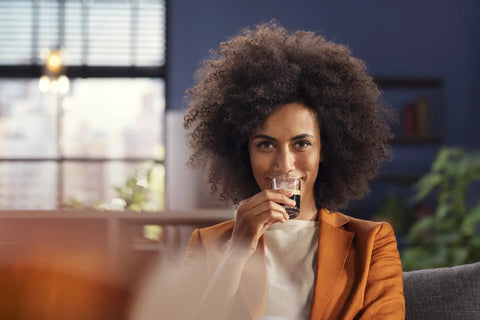 Woman enjoying espresso from Ready To Brew Renewed Fully Automatic Espresso Machine With Button Touch Controls.