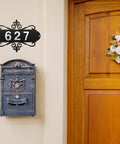 13.8 Inch Iron Address Plaque With Ten 2.75 Inch House Numbers displayed above a decorative mailbox on a home exterior wall.