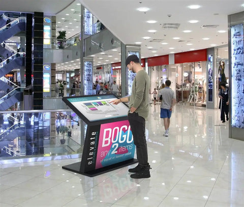 Top Shelf 49 Inch Interactive Touchscreen Kiosk With Smooth Ten Point Capacitive Panel And Rock Solid Android 11 Engine in a shopping mall.