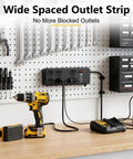 Heavy Duty Surge Protector Packing 3000 Joule Surge Defense 6 Outlet Beefy Metal Power Strip In Black mounted on a workbench with tools.