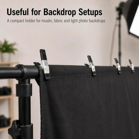 Straight Up Kicking 40 Pack Mini Spring Clamps Heavy Duty Nickel Plated Steel Clips For Quick Crafts Woodworking And Photography Backdrop Holds High Quality Genuine Grip applied to secure black fabric backdrop on a stand.