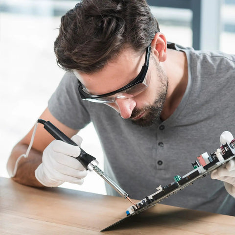 Person using soldering iron with 4 Piece 510 Thread Magnetic Adapter Kit Universal Threaded Screw Converter on circuit board.