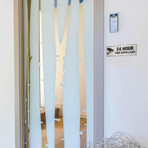 24 Hour Video Surveillance Sign 9x3 Inch Aluminum Silver Self Adhesive Metal Door Wall Sign on a frosted glass door