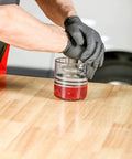 Using Deluxe Bearing Packer for quick grease flush and repack, fits roller and ball bearings up to 3.5 inches, durable polycarbonate construction.