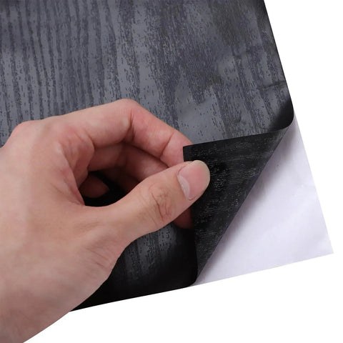 Close-up of hand peeling back No Sweat Peel And Stick Wallpaper For Kitchen Cabinets, Self Adhesive Vinyl Contact Paper.