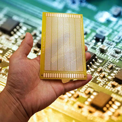 Hand holding Five Pack 9 By 15 Cm Single Sided Perf Board Stripboard For DIY Electronics And Arduino Projects FR4 Copper Clad