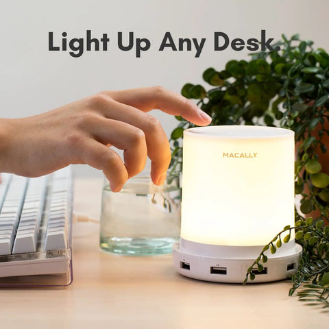 Touch Activated Nightstand Lamp With 4 USB Ports For Fast Charging, 3 Way Dimmable And Compact For Small Spaces on a desk.