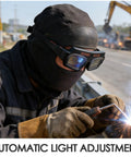 Solar Powered Auto Darkening Welding Glasses With Killer Panoramic View And Super Comfy Wraparound Fit For Top Shelf Eye Protection On Any Heavy Duty Metal Work Or Weekend Garage Build on a welder's face during fabrication.