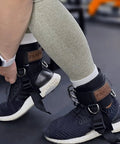 Secure Fit Two Pack Ankle Straps For Cable Machine With Crazy Comfy Neoprene Padding And Bombproof Steel Double Hooks in use with gym shoes.
