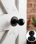 Two Pack Sliding Barn Door Handles Black Cast Iron Round Knobs With Vintage Distressed Texture And Ergonomic Grip For Shed Doors And Cabinets Pulls Heavy Duty Rustic Hardware installed on wooden door.