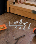 260 Piece M5 Nut Bolt And Washer Assortment Kit with Carbon Steel Spring Lock Washers on workbench during furniture assembly