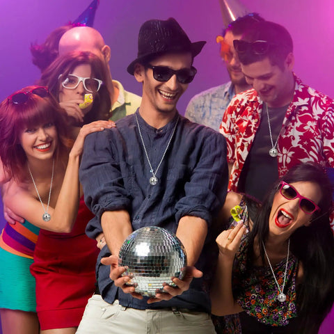 Group wearing Mirror Disco Ball Necklaces Set Of 20 Silver Hanging Ornaments For 70s Party, holding a large disco ball.