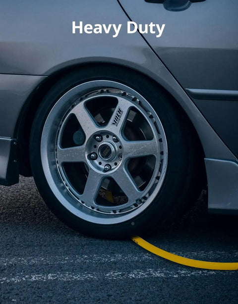 Grip And Go Hybrid Air Hose 3/8 Inch X 25 Feet With Quick Connect Fittings on the ground beside a car tire.