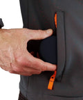 Person placing hard protective earphone case for earbuds and headphones in jacket pocket, showcasing compact size.