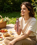 Person holding Copper Water Bottle 800ml Insulated Travel Cup With Anti Slip Grip during picnic