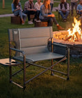 Beefy Heavy Duty XXL Director's Chair With Extra Wide 32 Inch Seat And 500 Lb Capacity, Padded Comfort Armrests beside campfire