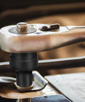 Pro Grade 14Millimeter 4 Point Square Impact Socket Half Inch Drive Cr Mo Steel Wheel Tool mounted on ratchet for rusted bolts.