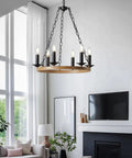 Six Light Farmhouse Chandelier with Rustic Industrial Wagon Wheel Design in Black hanging in a modern living room