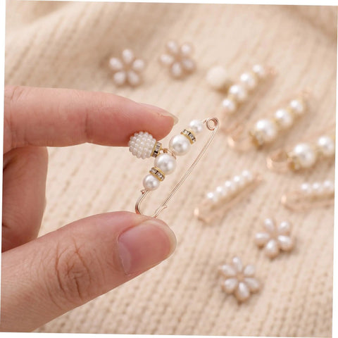 Close-up of Eight Piece Pearl Waist Tightener Pin Set Elegant Alloy Dress Cincher Clips held by hand with pearl details.