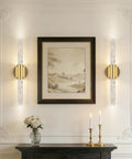 Elegant room with Battery Operated Wall Sconces Set Of 2 In Gold next to framed artwork on a white wall.