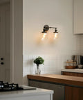 Vintage Industrial Double Wall Sconce in Black with Dual 5.9 Inch Clear Glass Globe Shades mounted on kitchen wall