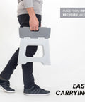 Person carrying Compact Foldable Step Stool for Adults Up to 330 Pounds, Lightweight Non Slip Gray Stool, Easy Fold design