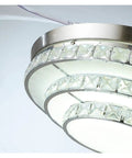 Close-up of 42 Inch Retractable Blade Ceiling Fan Featuring Glowing Crystal Chandelier and Smart Remote Controls.