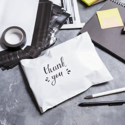 White poly mailer with 'thank you' text, part of 200 Pack Poly Mailers With Four Assorted Sizes 10 By 6 Inches, 11.8 By 7.8 Inches, 13.7 By 9.8 Inches, And 16.6 By 11.4 Inches Waterproof Tear Resistant White Shipping Envelopes For Clothes Books And More.