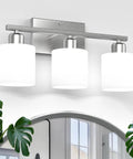 Three Bulb Over Mirror Bathroom Vanity Light In Brushed Nickel Finish Rustproof Wall Sconce Perfect For Wet Locations, mounted above a mirror.