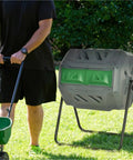 43 Gallon Dual Chamber Compost Tumbler With 360 Degree Rotation And 16 Aeration Vents on lawn next to gardener with cart