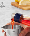 Pouring liquid into Stainless Steel Angled Measuring Jigger For Easy Reading From Above With Dual Ounce And Tablespoon Markings