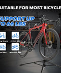 Red road bike on Floor Bike Repair Stand With Height Adjustable Arm And Tool Tray For Road And Mountain Bikes, 66 lb capacity.