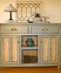 Rustic vintage cabinet with decorative elements and a table lamp on top, showcasing antique design and wooden texture.