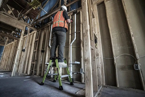 Worker using Sure Step 3 Step Double Sided Fiberglass Ladder Workhorse with Quick Setup Nylon Spreader Straps, Hi Viz Green