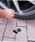 Heavy Duty Spare Tire Hold Down Bolt For Secure Tire Mounting And Easy Tightening Go To Car Spare Wheel Hardware For Reliable On Road Tire Replacement And Maintenance, man installing bolt on car wheel on brick pavement